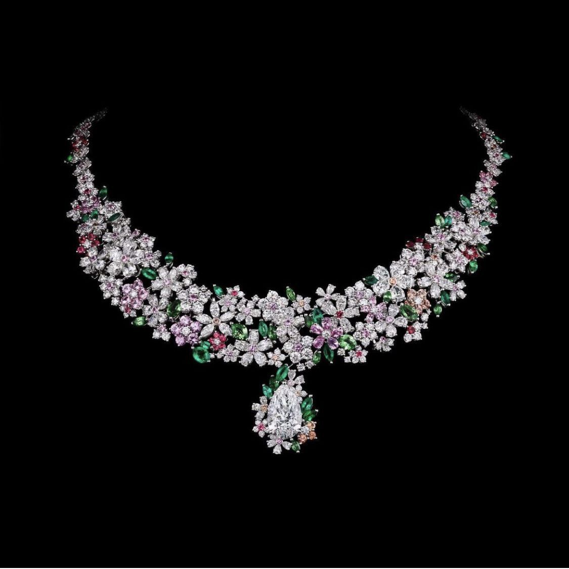a necklace with a floral center and pale drops
