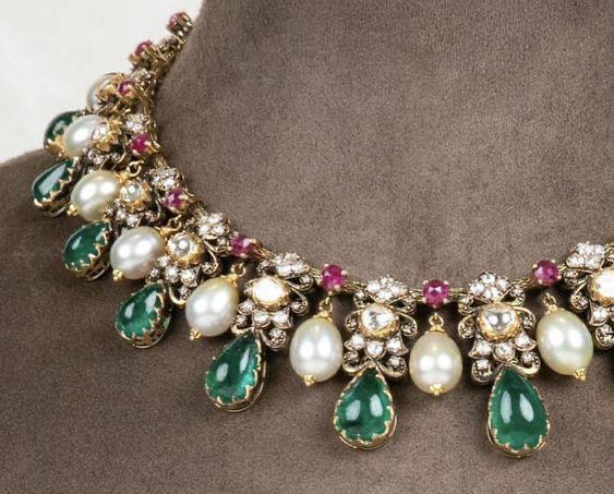 a curved necklace with repeated green-toned drops