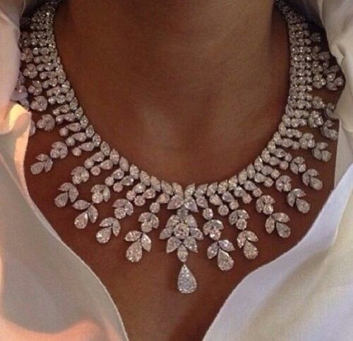 a broad necklace with repeating pale hanging details
