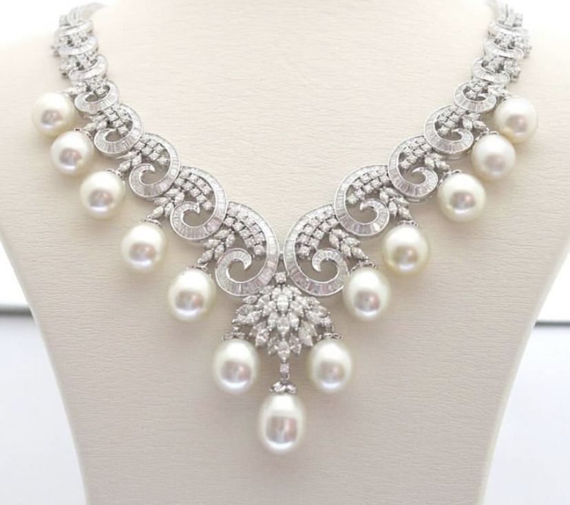 necklaces with a curved arrangement of pale round accents ending in hanging drops