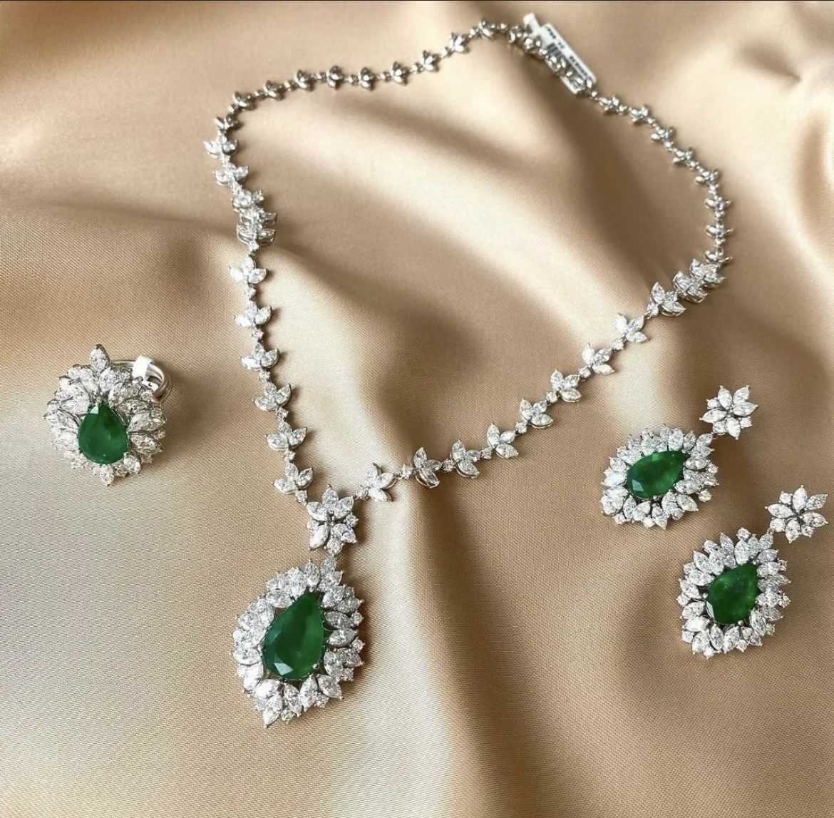 a necklace with a green-toned center shown with matching earrings