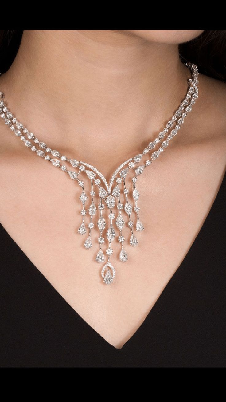 a curved necklace with repeating leaf-like bright details